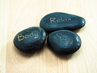 Black spa stones with relax body soul text on wood