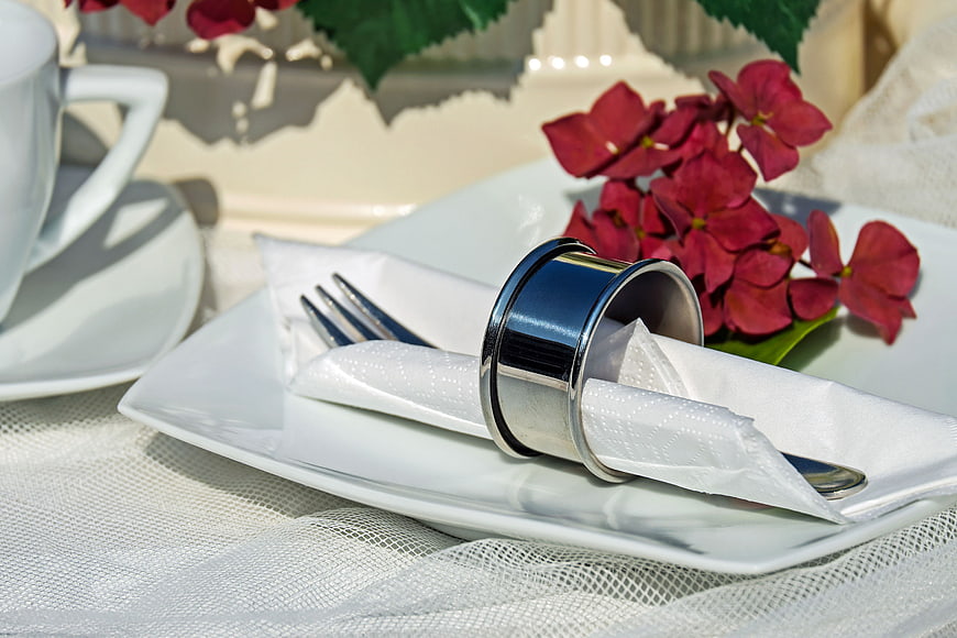 Elegant Table Setting with Silver Napkin Ring and Red Flowers