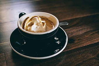 Cappuccino with whipped cream on rustic wooden table