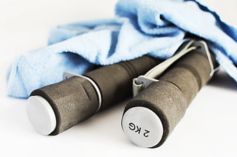 2kg dumbbells with blue towel on white background