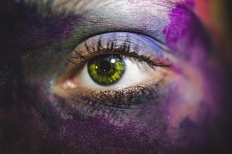 Close-up of green eye with colorful face paint