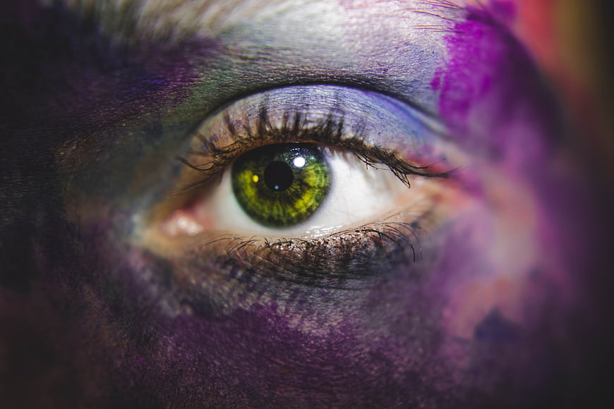 Close-up of green eye with colorful face paint
