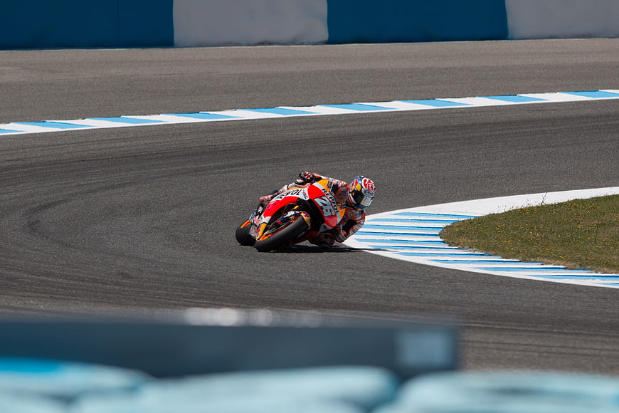 Motorcycle racer leaning into a turn on a professional racing circuit