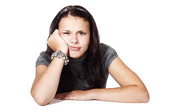 Bored teenage girl resting chin on hand isolated on white