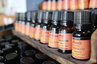 Rows of essential oil bottles on wooden shelf