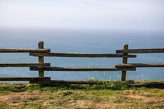 Rustic wooden fence overlooking the ocean on a sunny day