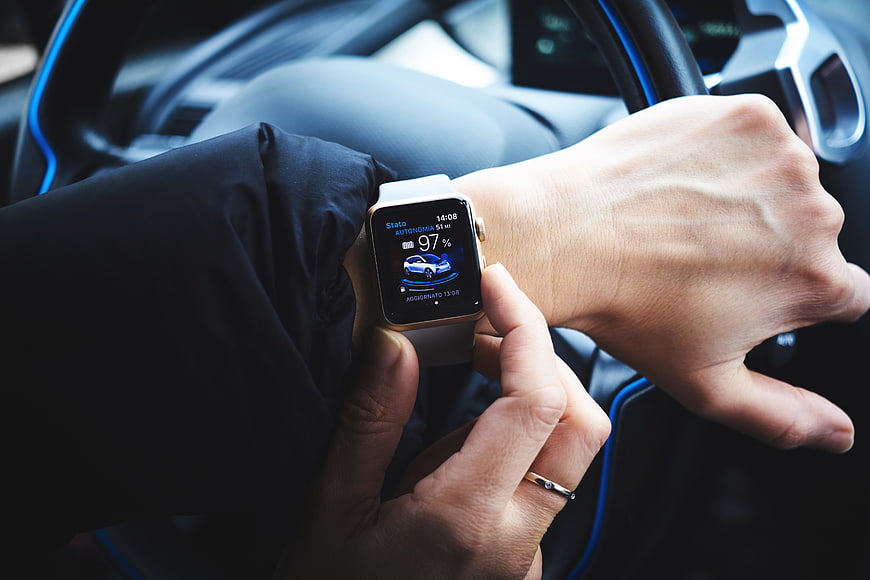 Smartwatch Displaying Electric Car Battery Status in Vehicle