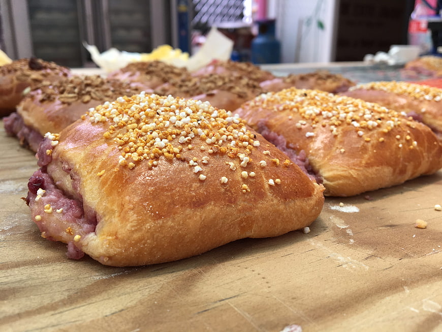 Freshly baked sweet bread rolls with crumb topping on wooden table