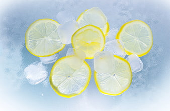 Fresh lemon slices and ice cubes on a cool blue background