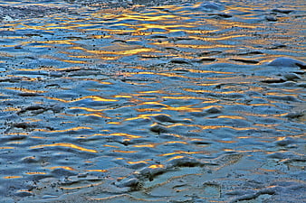 Golden sunset reflection on frozen icy winter landscape