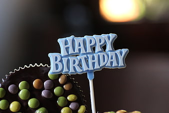 Close-up of chocolate cake pop with Happy Birthday topper