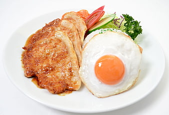 Sliced Pork Cutlet With Fried Egg And Fresh Salad On White Plate