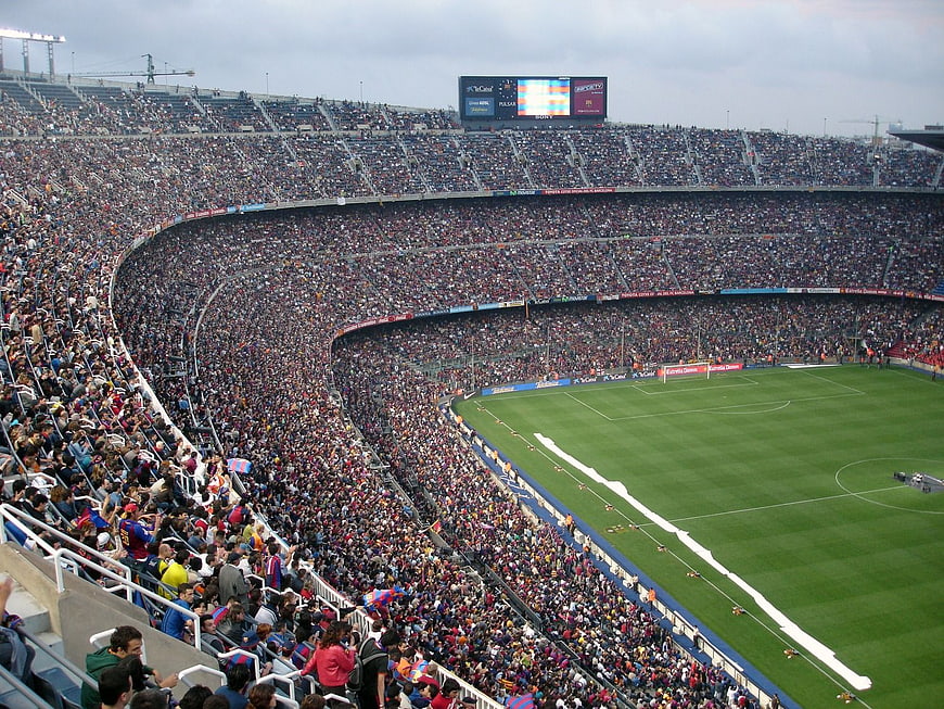 Wide view of crowded soccer stadium with green pitch