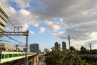 Green and White Commuter Train on Urban Tracks