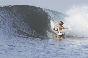 Surfer riding inside a large ocean wave barrel