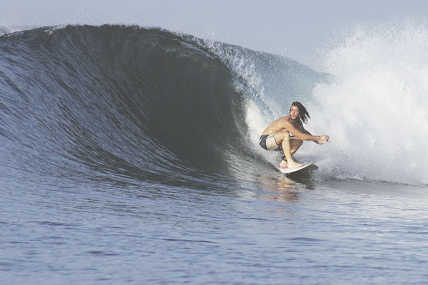 Surfer riding inside a large ocean wave barrel