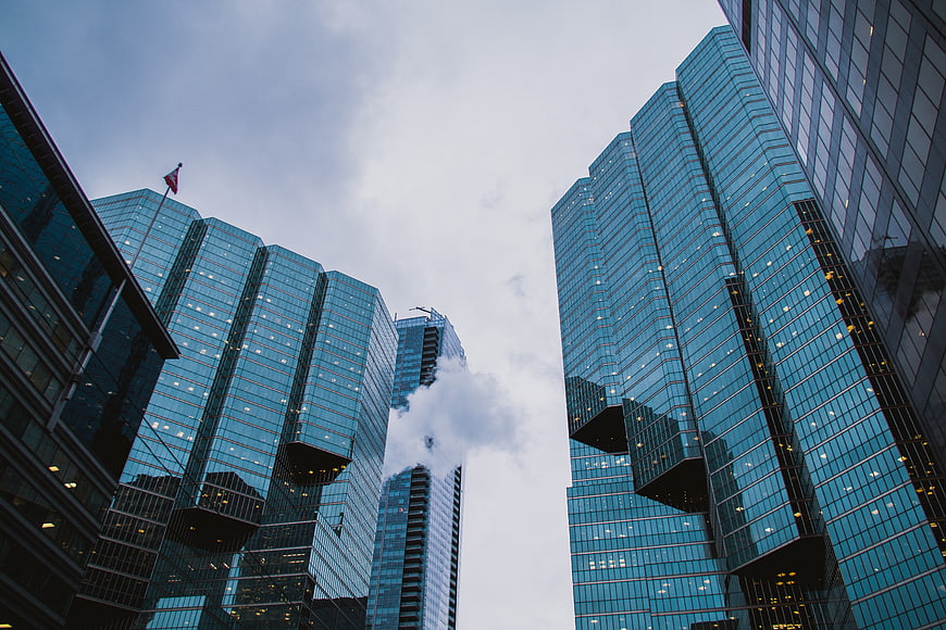 Low angle view of modern glass skyscrapers with smoke