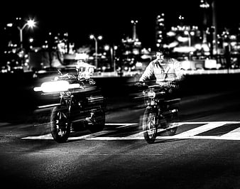 Two Motorcyclists Riding at Night in Black and White