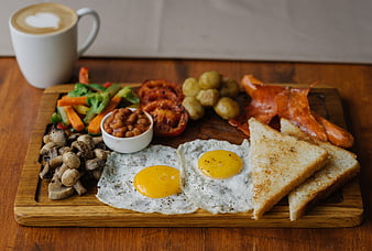 Full English breakfast on wooden board with coffee