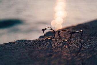 Eyeglasses on Rock by Ocean at Sunset