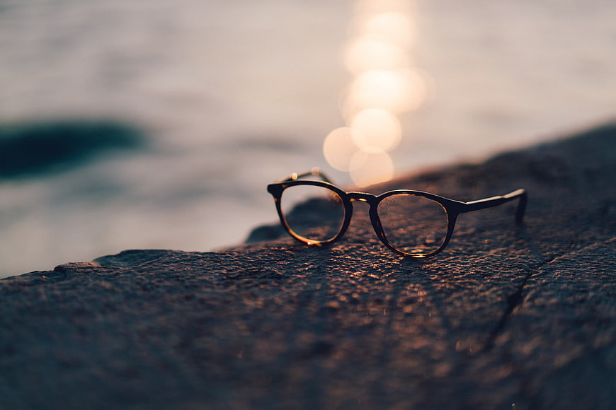 Eyeglasses on Rock by Ocean at Sunset