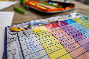 Close-up of a colorful handwritten school timetable on a wooden desk