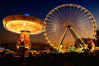 Time Lapse of Illuminated Ferris Wheel and Carousel at Night