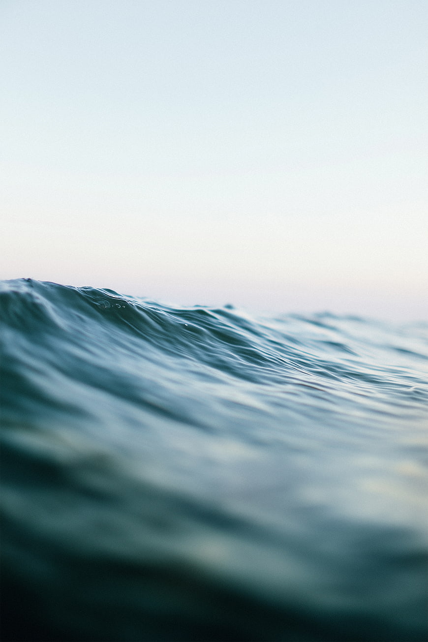 Serene Ocean Wave Crest with Soft Sky Background