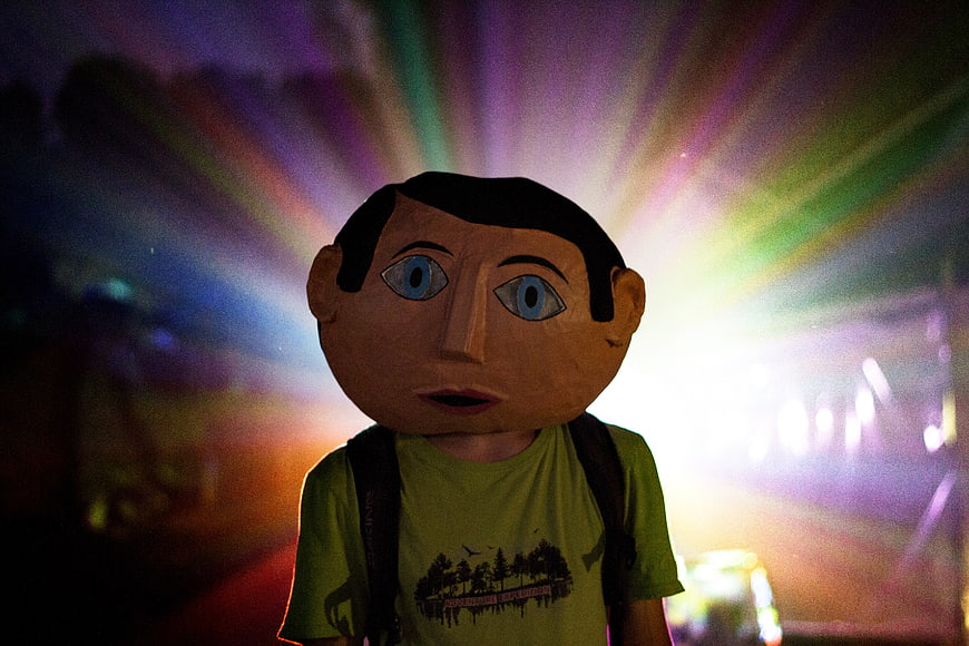 Person in Giant Paper Mask with Colorful Light Rays