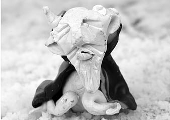 Handmade clay elf figurine sitting in snow