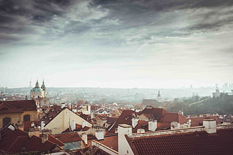 Dramatic cloudy sky over Prague rooftops and historic architecture