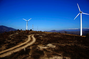 Wind turbines on a dry mountain ridge with blue sky