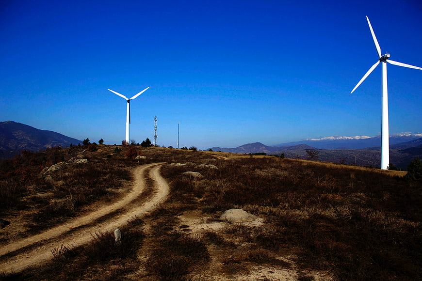 Wind turbines on a dry mountain ridge with blue sky