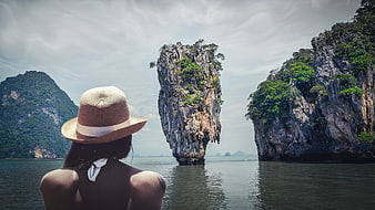 Woman in straw hat viewing James Bond Island in Thailand