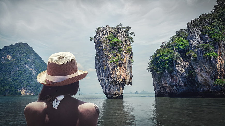 Woman in straw hat viewing James Bond Island in Thailand