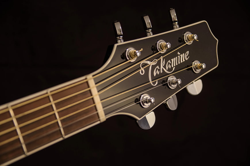 Close-up of Takamine Guitar Headstock on Black Background