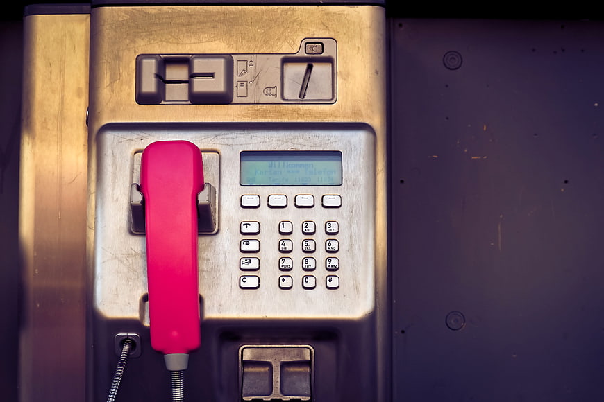 Close-up of vintage payphone with red handset