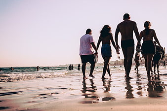 Group of Friends Walking on Beach at Sunset