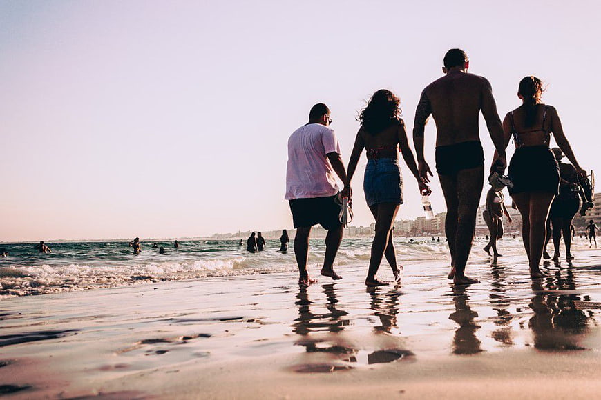 Group of Friends Walking on Beach at Sunset