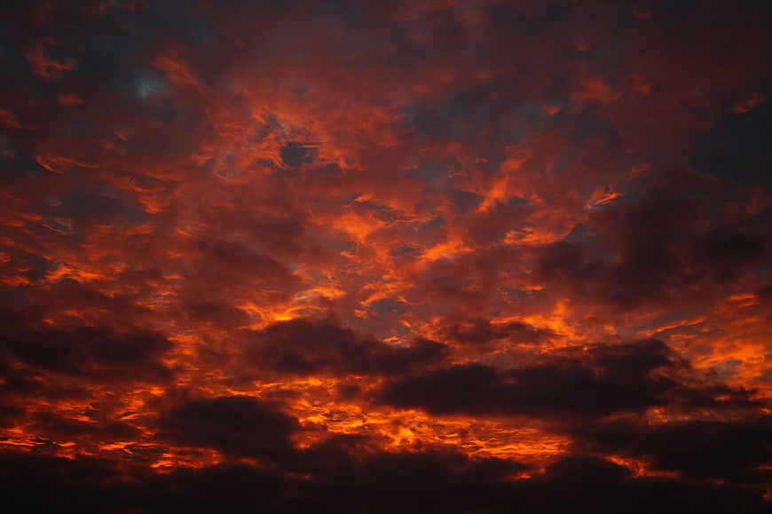 Dramatic fiery orange and red sunset clouds sky background