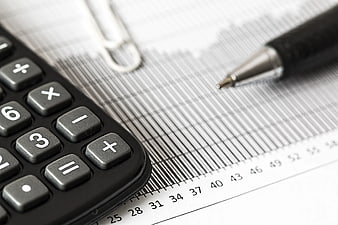 Calculator and Pen on Financial Chart