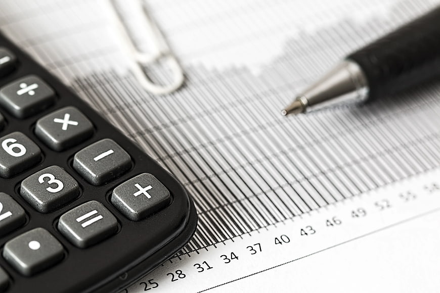 Calculator and Pen on Financial Chart