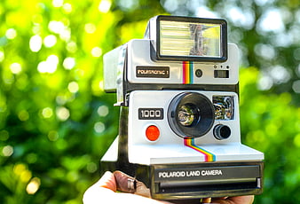 Vintage Polaroid 1000 Camera Held Against Green Nature Background