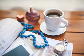 Morning coffee with blue beads and watch on wooden table