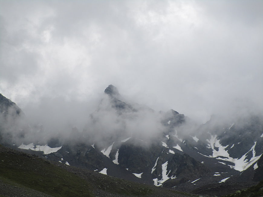 Misty mountain peaks with snow patches in the alps