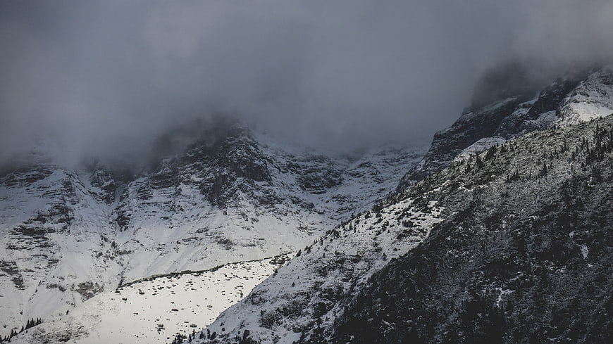 Snowy mountain landscape with clouds and fog