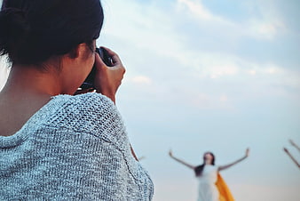Photographer Taking Photo of Woman with Arms Raised