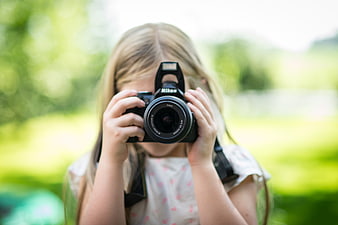 Young Girl Holding DSLR Camera Outdoors