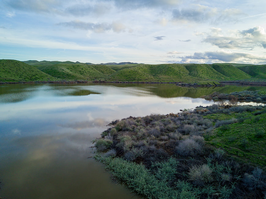 Serene river winding through green rolling hills landscape