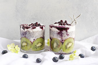 Healthy chia seed pudding with kiwi and blueberries in glass jars
